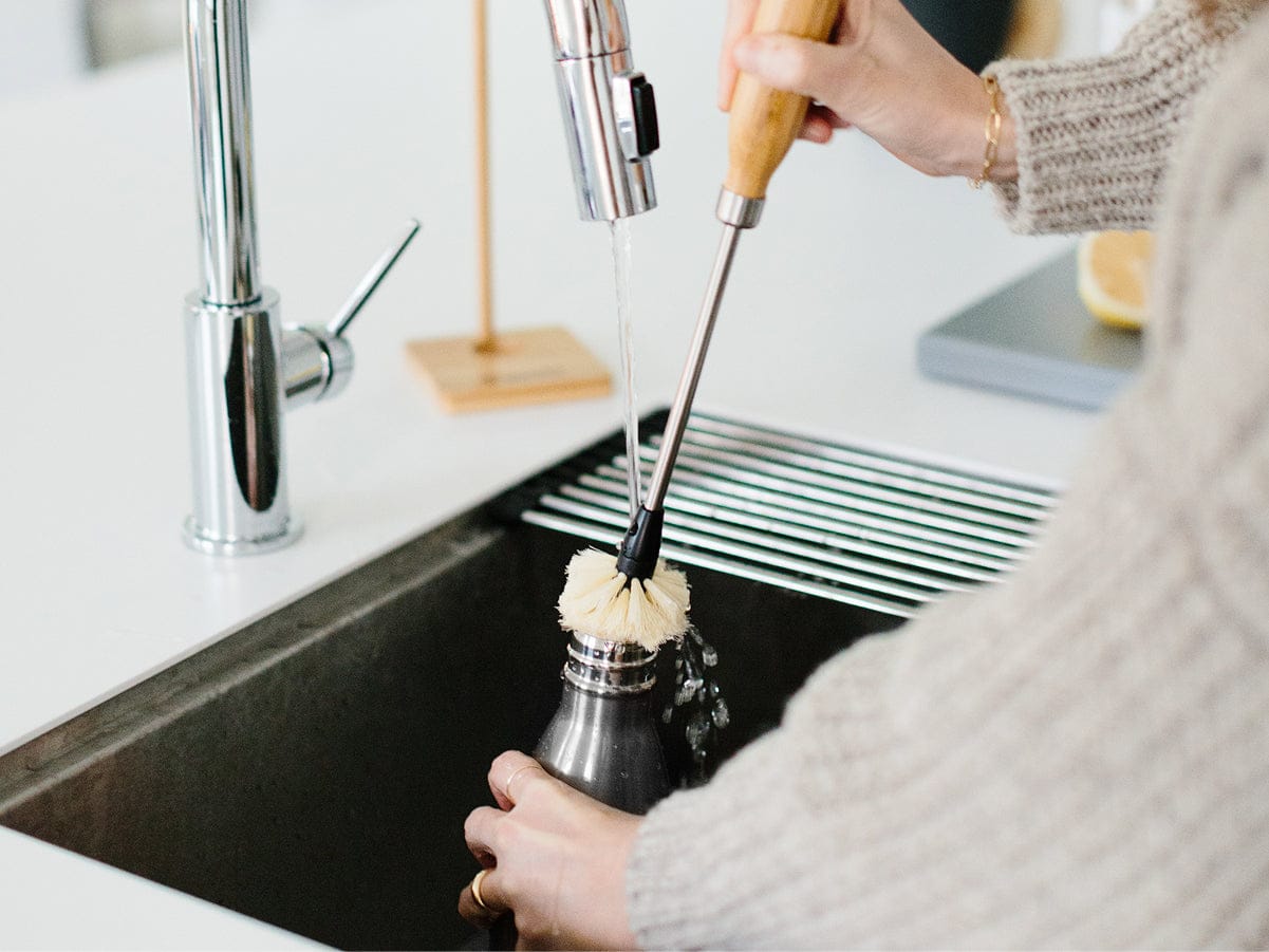 Cleaning Original Bottle with brush in sink
